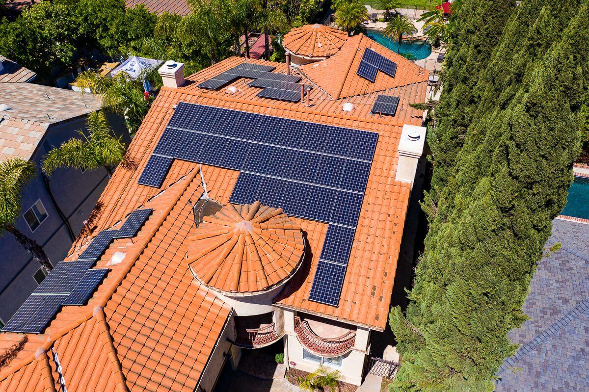 Solar panels installed on a large terracotta-tiled roof of a ...